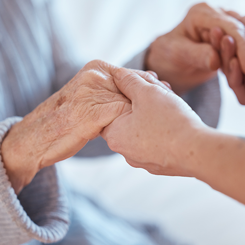 Career holding hands with elderly patient in Fareham